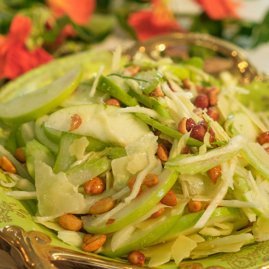Green salad with nuts on a decorative plate, set against a floral background