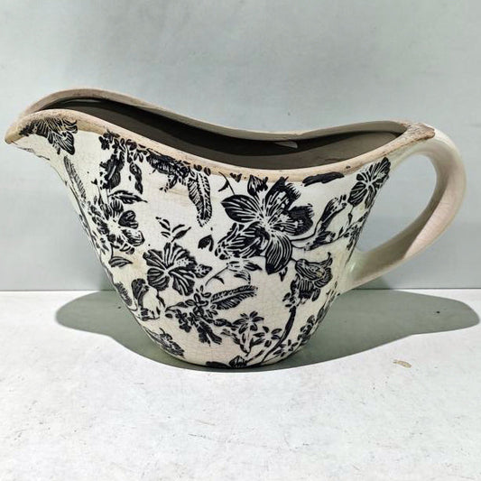 Ceramic pitcher with floral pattern on a white background