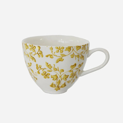 White mug with gold floral pattern on a white background