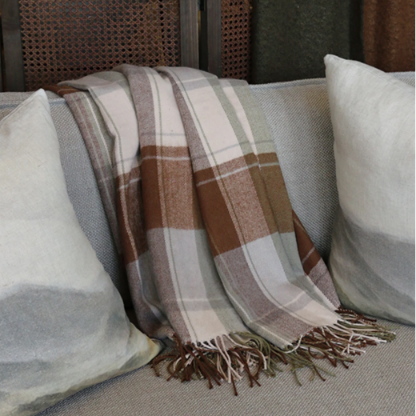Plaid blanket draped over a couch with pillows
