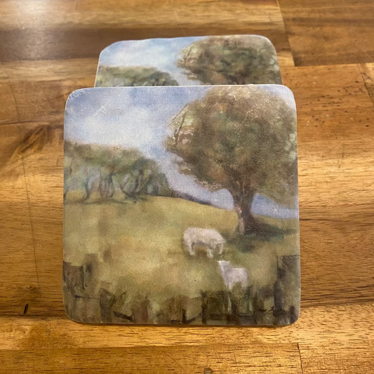 A set of four square resin coasters with a handpainted New Zealand rural scene including trees and sheep.