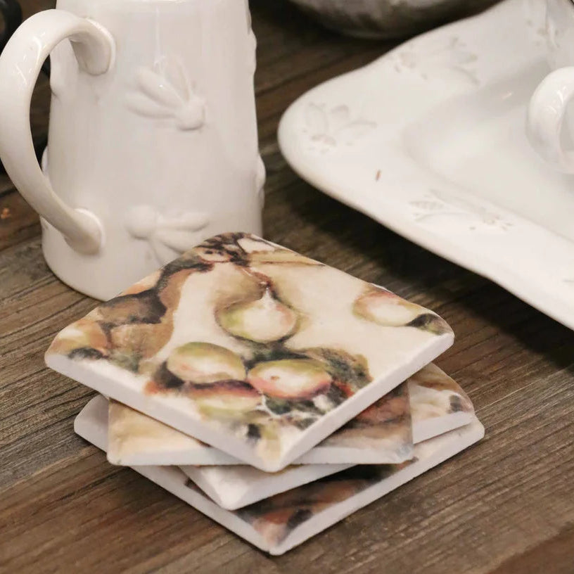 White ceramic mug and coasters with shell design on a wooden surface