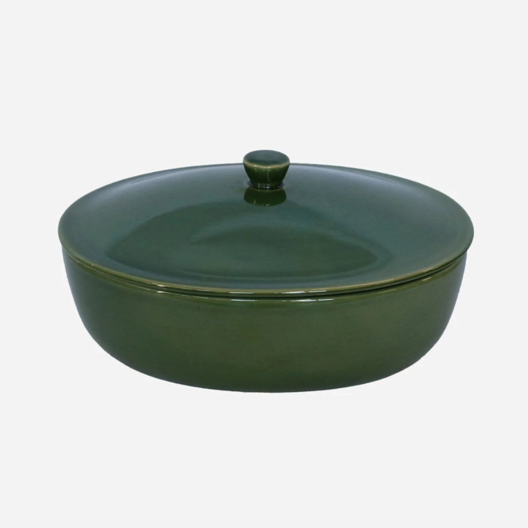 Green ceramic casserole dish with lid on a white background