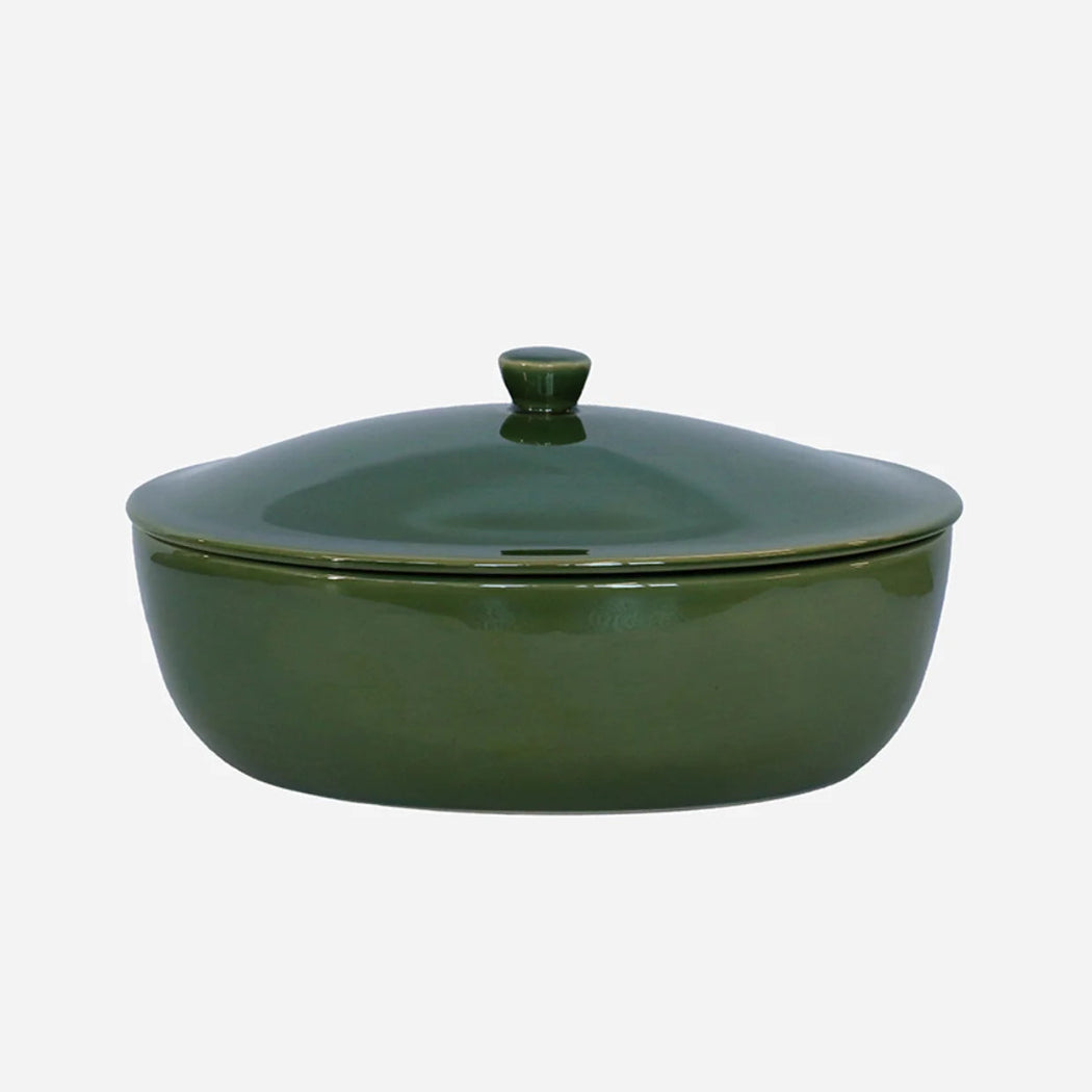 Green ceramic casserole dish with lid on a white background
