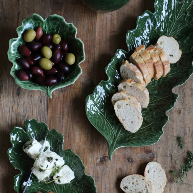 Green leaf-shaped ceramic plates with food on a wooden surface