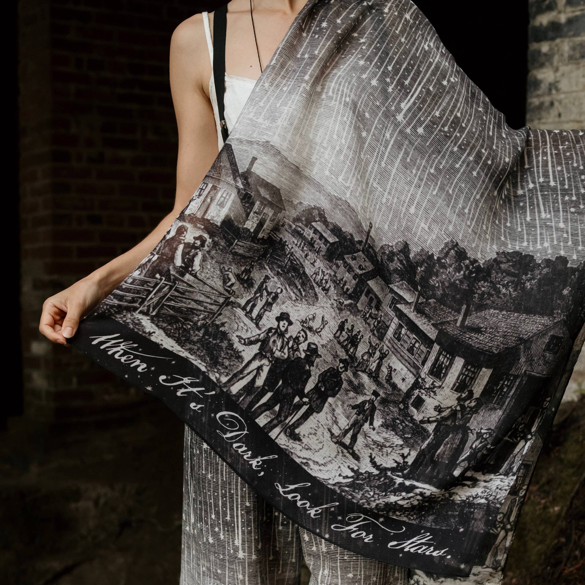 Person holding a black and white patterned bag with historical design