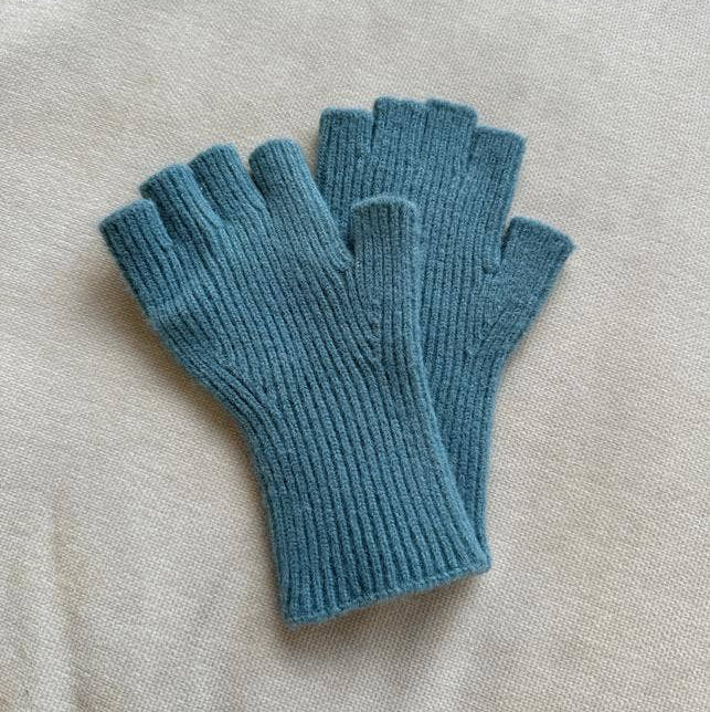Pair of blue fingerless gloves on a beige surface