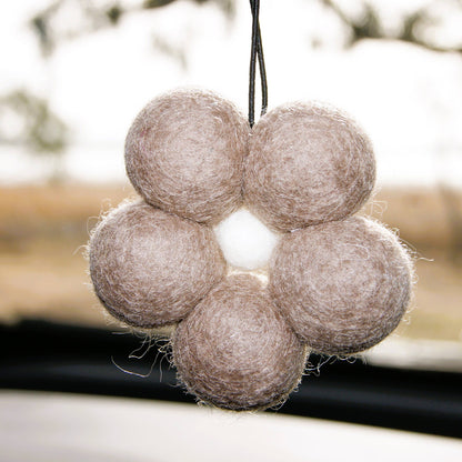 Decorative hanging with felt balls on a blurred natural background