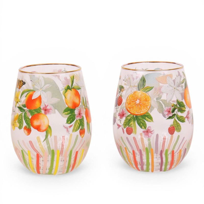 Two stemless wine glasses with floral and fruit design on a white background