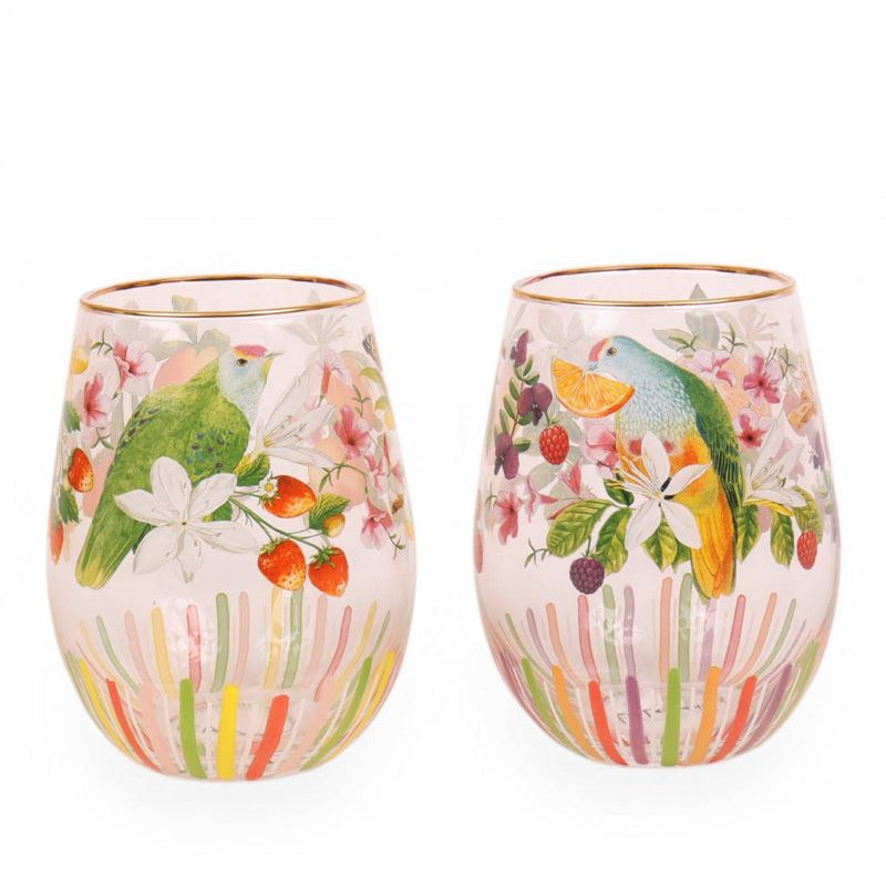 Two stemless wine glasses with tropical bird and floral design on a white background