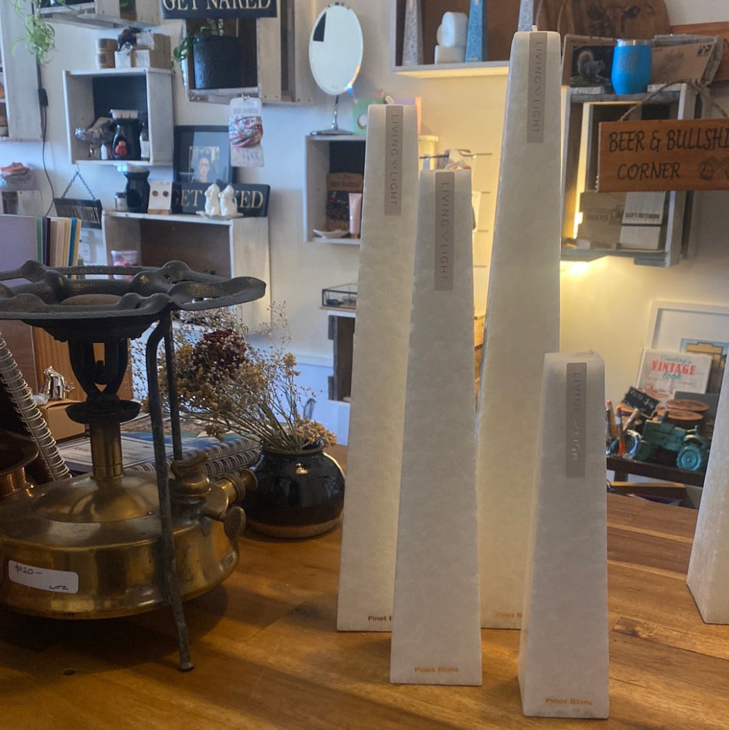 A selection of sculptural candles in various sizes with a white crystalline structure, displayed in a retail setting.