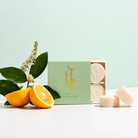 Box of candles with lemon slices and leaves on a light green background