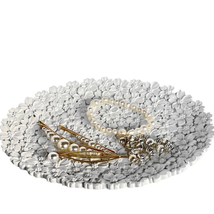Pearl necklace with decorative elements on a textured white surface