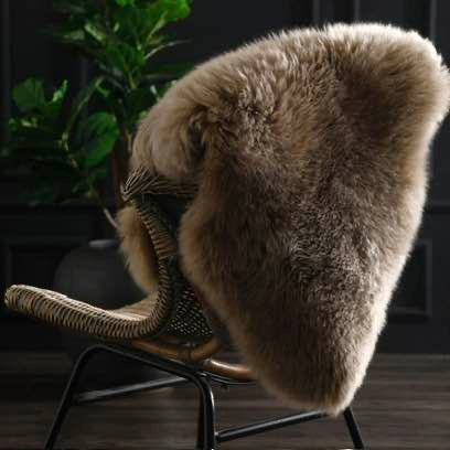 Chair with a taupe sheepskin cover in a dark room