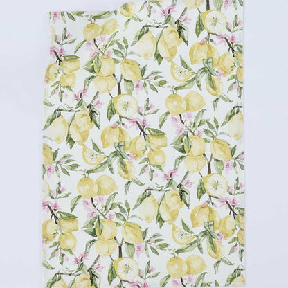 A rectangular kitchen towel or tea towel featuring a watercolor-style lemon and blossom print on a white background, photographed flat against a light gray studio backdrop.