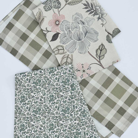 Three folded tea towels with different patterns displayed on a white background: a green and beige gingham, a cream floral print with pink flowers and green leaves, and a sage green and white floral print.