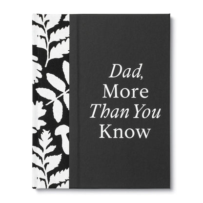 A hardcover book or journal with a black cover featuring the white text 'Dad, More Than You Know' and a black-and-white botanical leaf pattern spine panel, shown on a white background.
