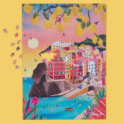 A colorful jigsaw puzzle depicting a coastal town with bright buildings, boats in the water, birds, and yellow lemons hanging from branches, shown on a yellow background with a few loose puzzle pieces nearby.