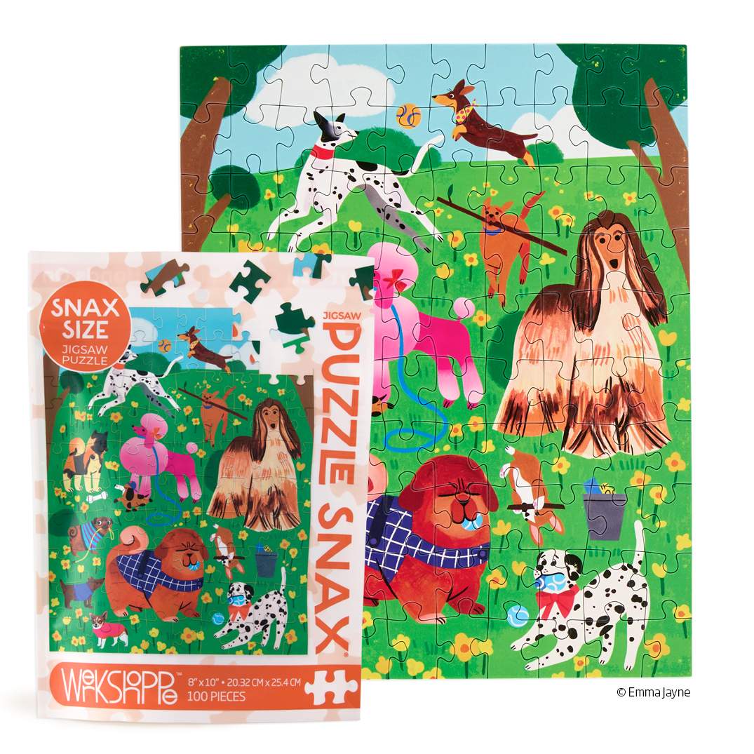 A colorful dog-themed jigsaw puzzle and its retail box shown on a white background. The puzzle features playful dogs in a grassy field with trees, and the box reads 'SNAX SIZE PUZZLE PUZZLE SNAX' with '200 PIECES' at the bottom.