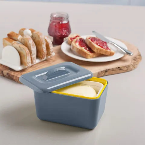 Butter container with bread and jam on a table